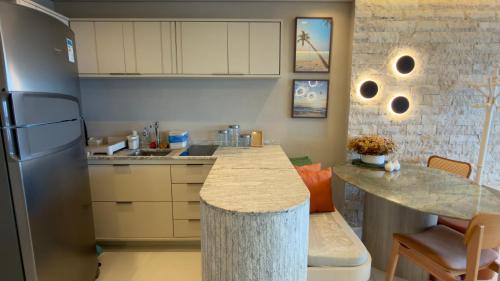 a kitchen with a counter and a refrigerator at Ondina Apart Hotel Residences in Salvador