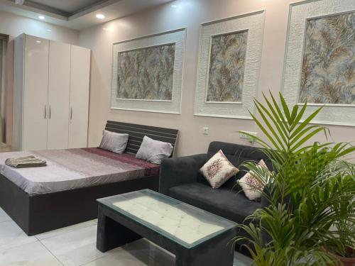a living room with a couch and a bed at StayVerse74 in Noida