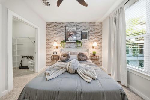 a bedroom with a large bed and a brick wall at Stylish 2BR w Balcony, Pool & Pet-Friendly #15 in Tampa