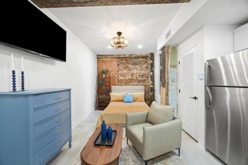 a room with a bed and a refrigerator and a chair at Park Hotel Studio Suite 203 in Chattanooga