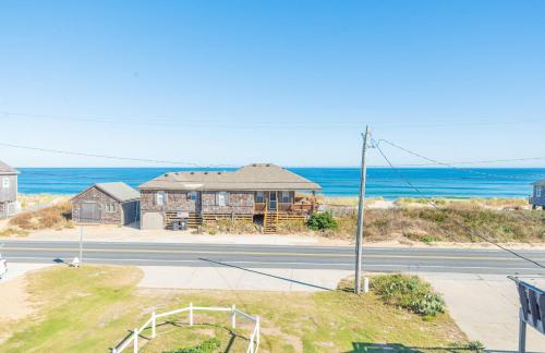 a house on the side of a road next to the ocean at Sea Sun Greetings - Kitty Hawk MP 2.5, Ocean Views, Direct Beach Access, Pool, Hot Tub, Pets OK in Kitty Hawk