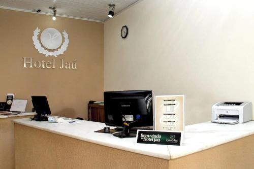 an office counter with a hotel law sign on the wall at Hotel Jaú in Jaú