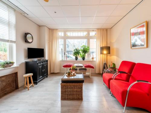 a living room with a red couch and a tv at Apartment in Bergen near Sandy Beaches in Bergen