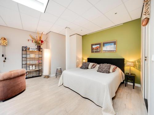 a bedroom with a white bed and a green wall at Apartment in Bergen near Schoorl Dunes in Bergen