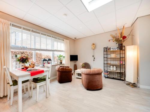 a dining room with a white table and chairs at Apartment in Bergen near Schoorl Dunes in Bergen