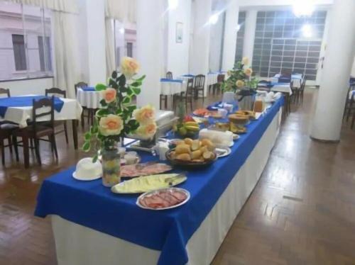 a long blue table with plates of food on it at Hotel Jaú in Jaú