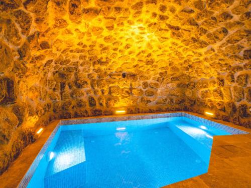 a swimming pool in a cave with a stone wall at Atilla's Cave Hotel in Nevşehir
