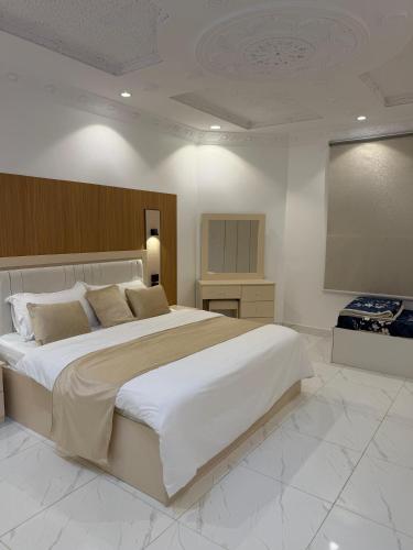 a large bedroom with a large bed and a television at النبلا الذهبي in Medina
