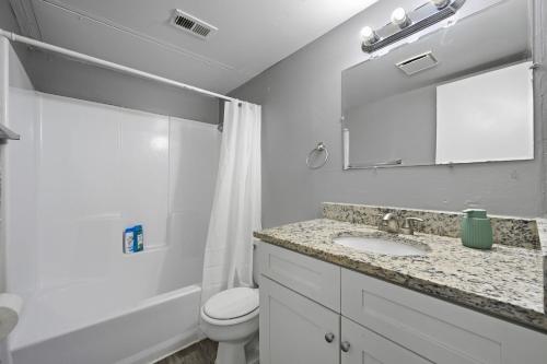 a bathroom with a sink and a toilet and a mirror at Bright two-bed wupgraded fixtures in Denton