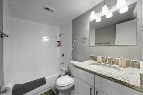a bathroom with a sink and a toilet and a mirror at Denton pad with 2BR comfort in Denton