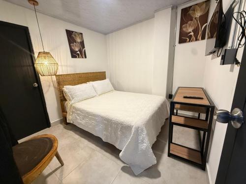 a small bedroom with a bed and a table at Toba hotel boutique in Ibagué