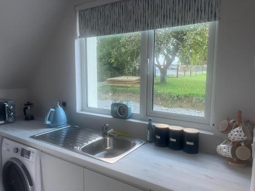 a kitchen counter with a sink and two windows at Peter's Loft in Melbourne Bridge