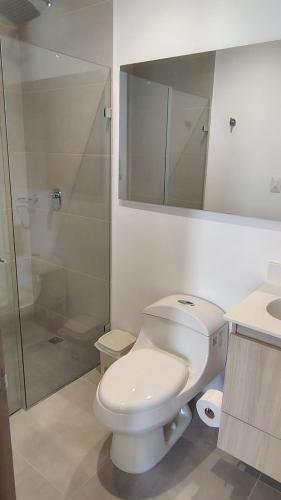 a white bathroom with a toilet and a shower at Salguero sunset resort apartmento in Gaira