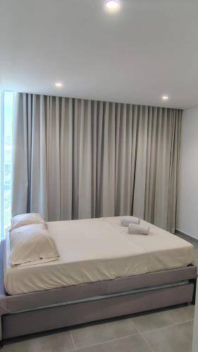a large bed in a room with a window at Salguero sunset resort apartmento in Gaira