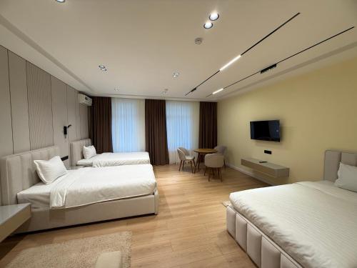 a hotel room with two beds and a television at Golden Valley Hotel in Tashkent