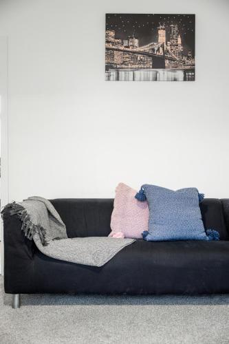 a black couch with pillows on it in a room at 52 Furnival Road, Manchester in Manchester