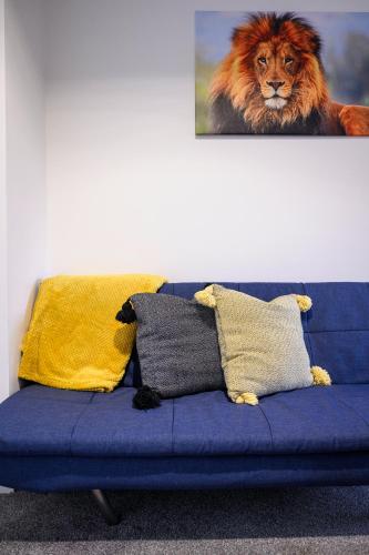 a blue couch with a lion picture on the wall at 52 Furnival Road, Manchester in Manchester