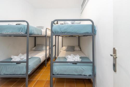 two bunk beds in a room with a door at A pie de Playa, Casa de Pescadores en Calella in Calella de Palafrugell