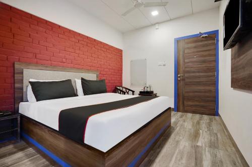 a bedroom with a large bed with a red brick wall at Super Collection O Kalinga Bapuji Nagar in Bhubaneshwar