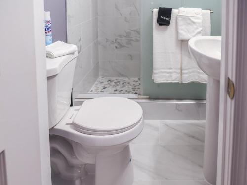 a white bathroom with a toilet and a sink at Stylish Studio Escape - Calm & Convenient Lanham in Lanham