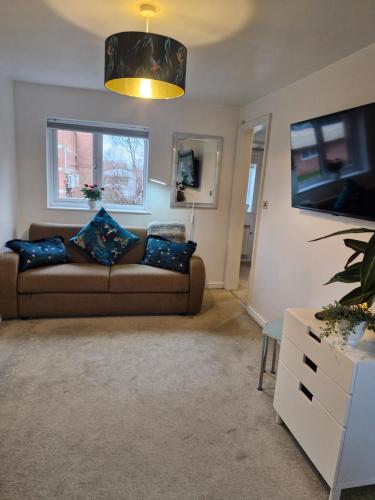 a living room with a couch and a tv at 4 Bancroft place in Stratford-upon-Avon