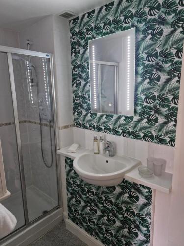 a bathroom with a sink and a shower and a mirror at 4 Bancroft place in Stratford-upon-Avon