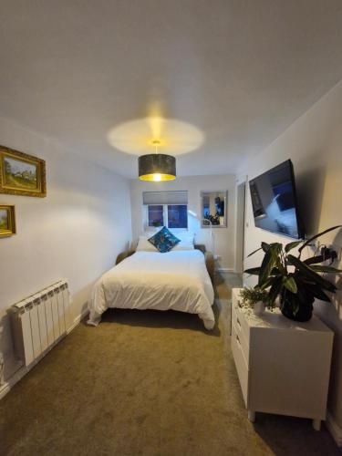 a bedroom with a white bed and a tv at 4 Bancroft place in Stratford-upon-Avon