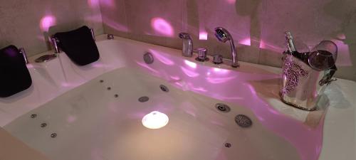 a bathroom with a white tub with a candle in it at Lilli & Evoque Apartments in Civitanova Marche