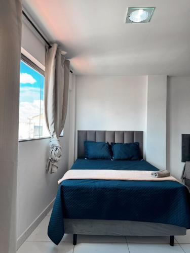 a bedroom with a blue bed and a window at Margem do São Francisco 104 praiano in Petrolina