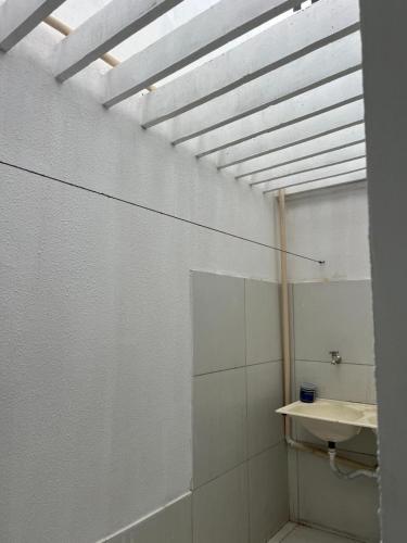 a bathroom with a white wall with a skylight at Margem do São Francisco 104 praiano in Petrolina
