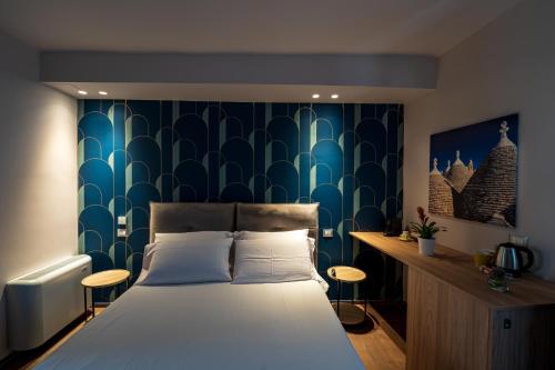 a bedroom with a bed and a blue wall at B&B Arcolobello ApartHotel in Corato