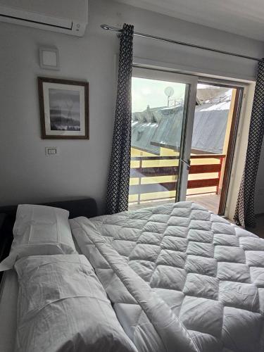 a bedroom with a large bed and a large window at BENNY'S MOUNTAIN b&b in Pescocostanzo