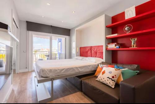 a bedroom with a bed and a couch at Little Dream Apartment Sitges in Sitges