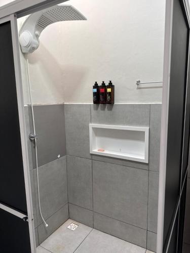 a bathroom with a shower with bottles on the wall at Casa privativa Próximo a Itaipu in Foz do Iguaçu