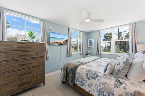 a bedroom with a bed with a dresser and windows at Clearwater Beach Suites #201 in Clearwater Beach