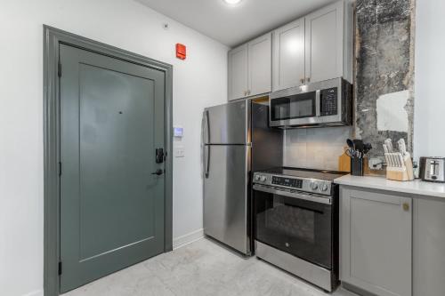 a kitchen with a stainless steel refrigerator and a microwave at Park Hotel 1BR Suite 402 in Chattanooga