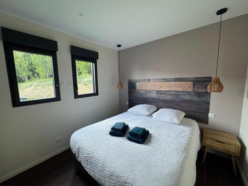 a bedroom with a bed with two blue towels on it at Le Buchon Lodge in Montcornet