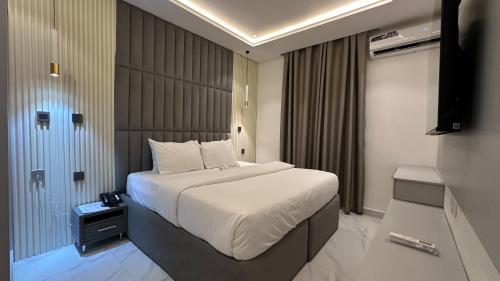 a hotel room with a bed and a television at Bayford Suites in Abuja