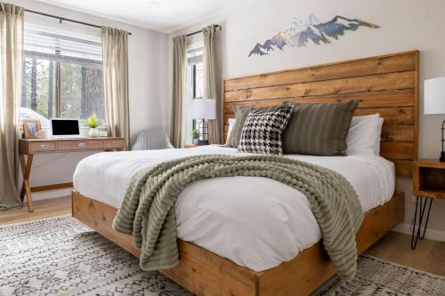 a bedroom with a large bed with a wooden headboard at Pine Cone Cabin Flagstaff 3BR 2BA in Flagstaff