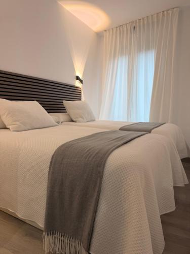 a bedroom with two beds and a window at Apartamento Las Cruces in Plasencia