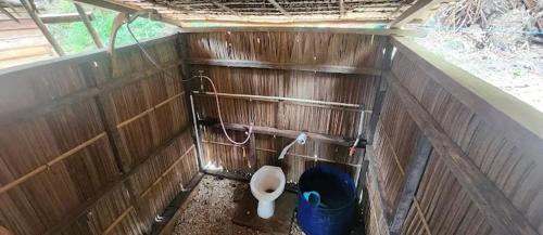 a bathroom with a toilet in a wooden wall at Mantorom homestay in Yennanas Besir