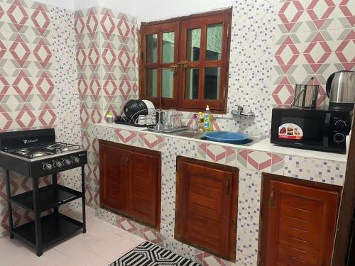 una cucina con un lavandino e un fornello di Residence Nelo a Abidjan