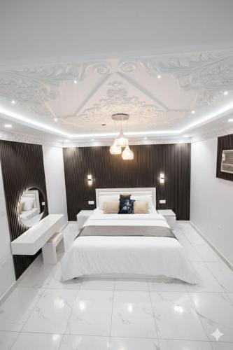 a bedroom with a large white bed and a ceiling at مرافئ in Medina