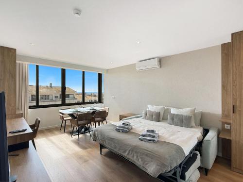 a hotel room with a bed and a dining room at Ocean Breeze Rooms, Albufeira in Albufeira