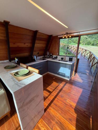 a kitchen in a house with wooden walls and wood floors at Nature Senses Chapadinha in Cavalcante