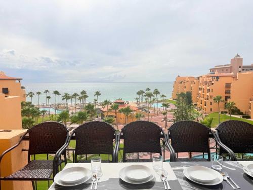 a table with chairs and a view of the ocean at Princesa 3BR 2BA OV Penthouse- 502D in Campo del Medio