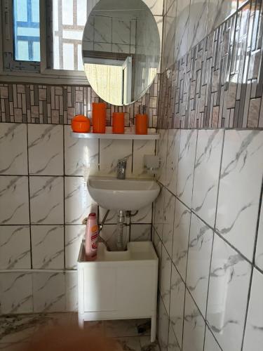 a bathroom with a sink and a mirror at Villa Golden Gâte 8 Bred room in Dombé
