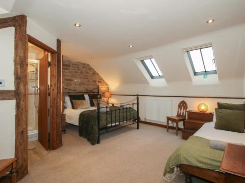 a bedroom with two beds and two windows at Corn House in Plaish