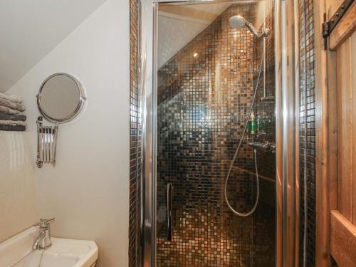 a bathroom with a shower with a glass door at Corn House in Plaish
