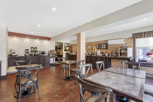 a kitchen and dining room with tables and chairs at Best Western Plus Otonabee Inn in Peterborough